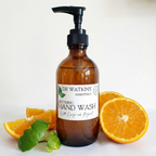 Dr. Watkins essentials soothing hand wash bottle with pump, surrounded by orange slices and bergamot on a white background.